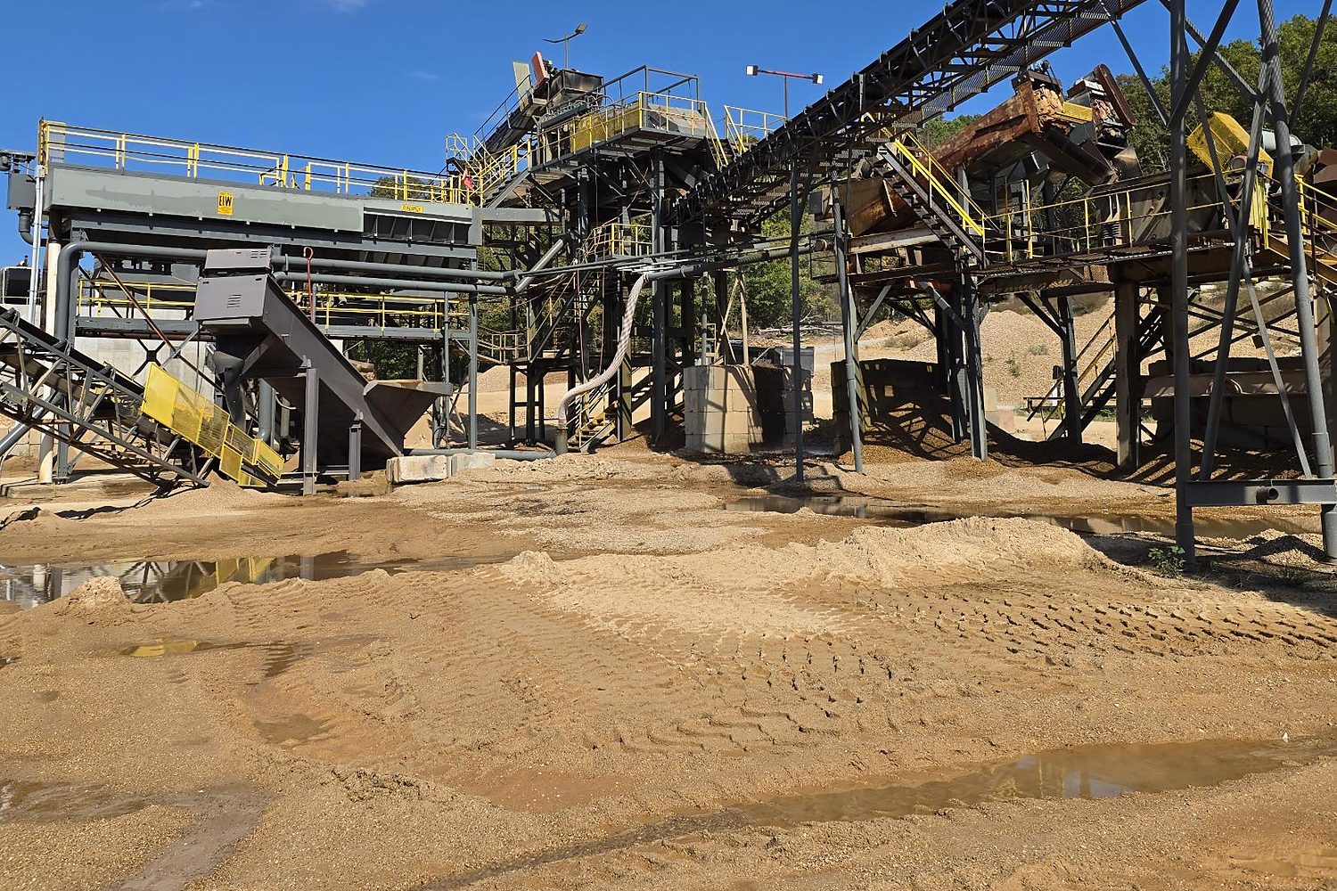 Sand and gravel wash plant with screens and conveyors seen from the pit floor